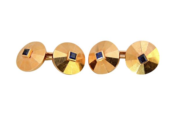 A pair of gold and sapphire set dress cufflinks, each faceted circular back and front mounted with a square cut sapphire at the centre, in a 1940's de