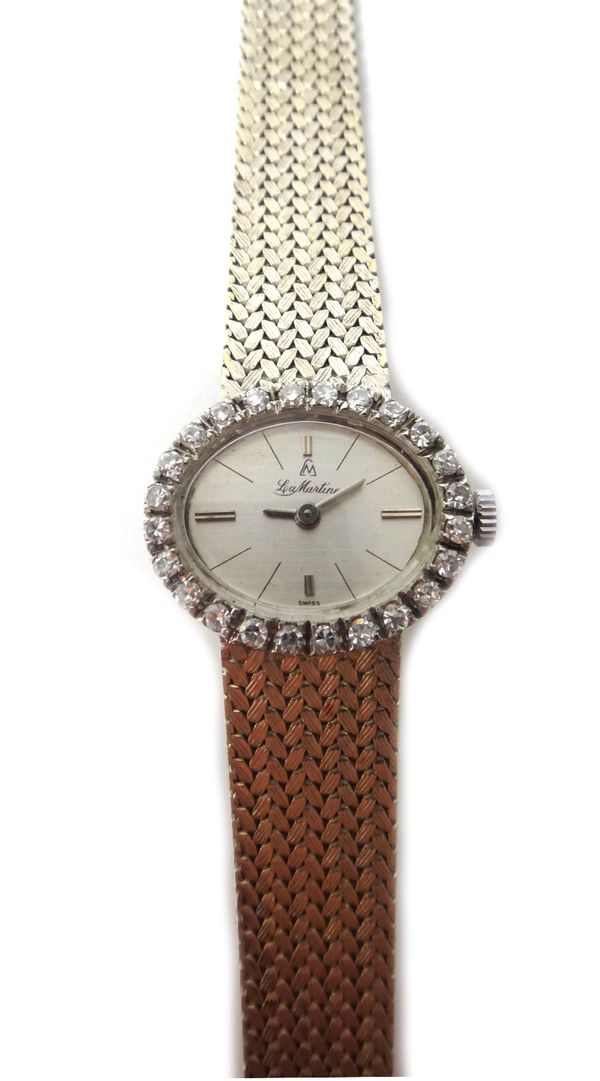 A lady's white gold and diamond set La Martine bracelet wristwatch, the oval silvered dial with baton shaped numerals, the bezel mounted with a surrou