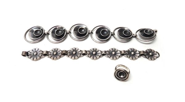 A Swedish bracelet, the links formed as a row of flowerheads, on a hook shaped clasp, a Scandinavian bracelet, the links in a circular and dish shaped