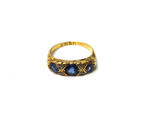 An 18ct gold, sapphire and diamond set ring, mounted with three cushion shaped sapphires and with two pairs of small cushion shaped diamonds mounted a