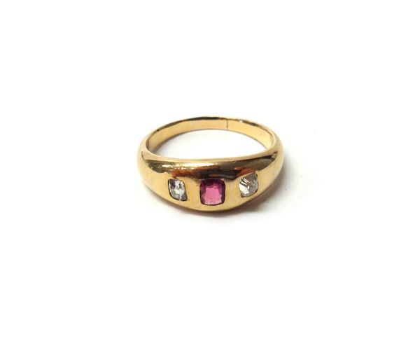 A gold, ruby and diamond set three stone ring, gypsy set with the cushion shaped ruby at the centre, between two cushion shaped diamonds, ring size Q.