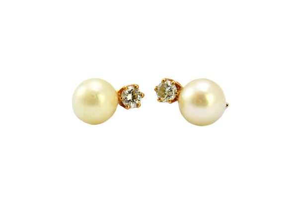 A pair of gold, diamond and cultured pearl earrings, each claw set with a circular cut diamond above a single cultured pearl, with post and folding cl