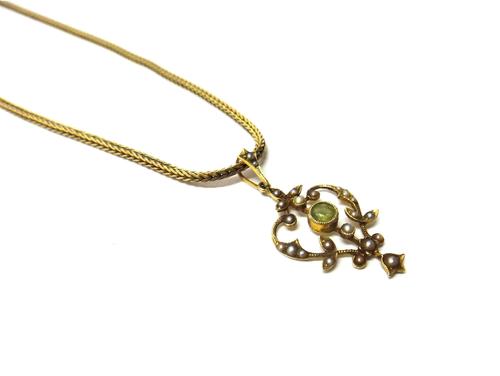 A 9ct gold foxtail link neckchain, on a gilt metal clasp and a gold peridot and seed pearl set pendant, in a pierced scrolling design, detailed 15 C,