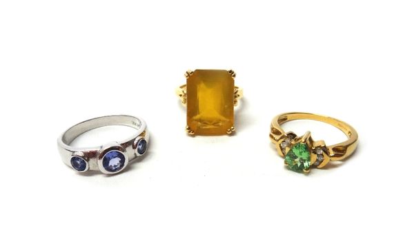 An 18ct white gold ring, collet set with three circular cut tanzanites, an 18ct gold, diamond and pale green gem set ring and an 18ct gold ring, claw