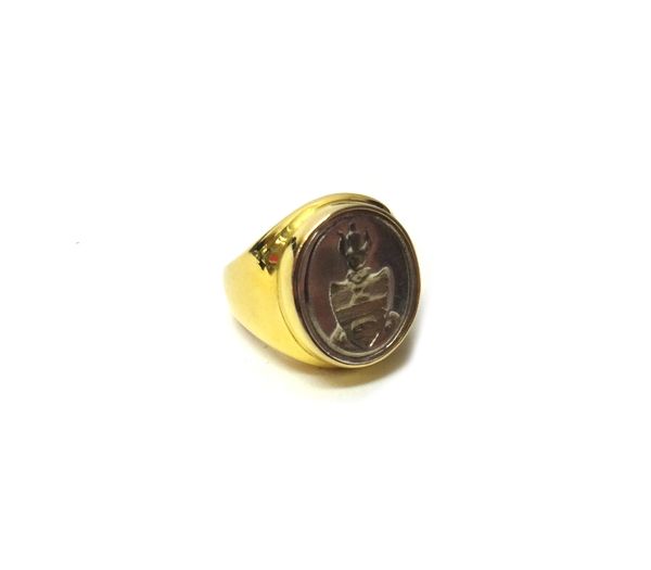 A gold and silver intaglio set signet ring, with a shield and a bell crest design, ring size L and a half, gross weight 20.2 gms, with a case.