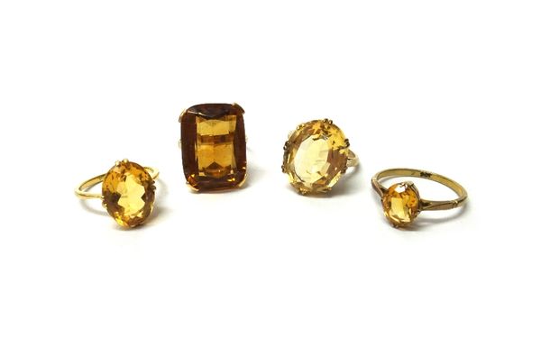 A gold ring, claw set with an oval cut citrine, detailed 18 CT, a gold ring, claw set with a larger oval cut citrine, detailed 9 CT and two further go