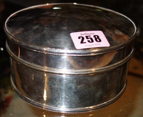 A silver plated on copper, hinge lidded cylindrical box, having decorated borders in the Arts & Crafts taste, diameter 14cm.