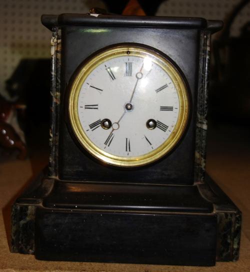 A black slate mantel clock, a Japanese vase, a marble obelisk and accordion.