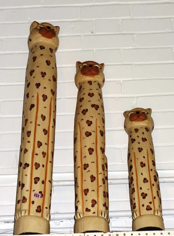 A group of three graduated carved wooden models of Cheetahs.