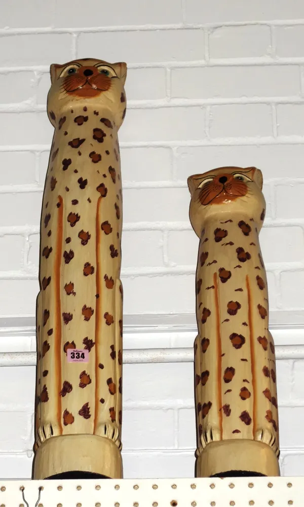 A group of two carved graduated wooden models of cheetahs.