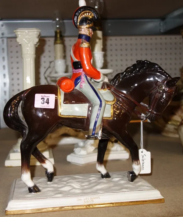 A ceramic figure of a soldier on horseback, two faux bamboo ceramic table lamps and a cream porcelain corinthian column type candlestick. (4)