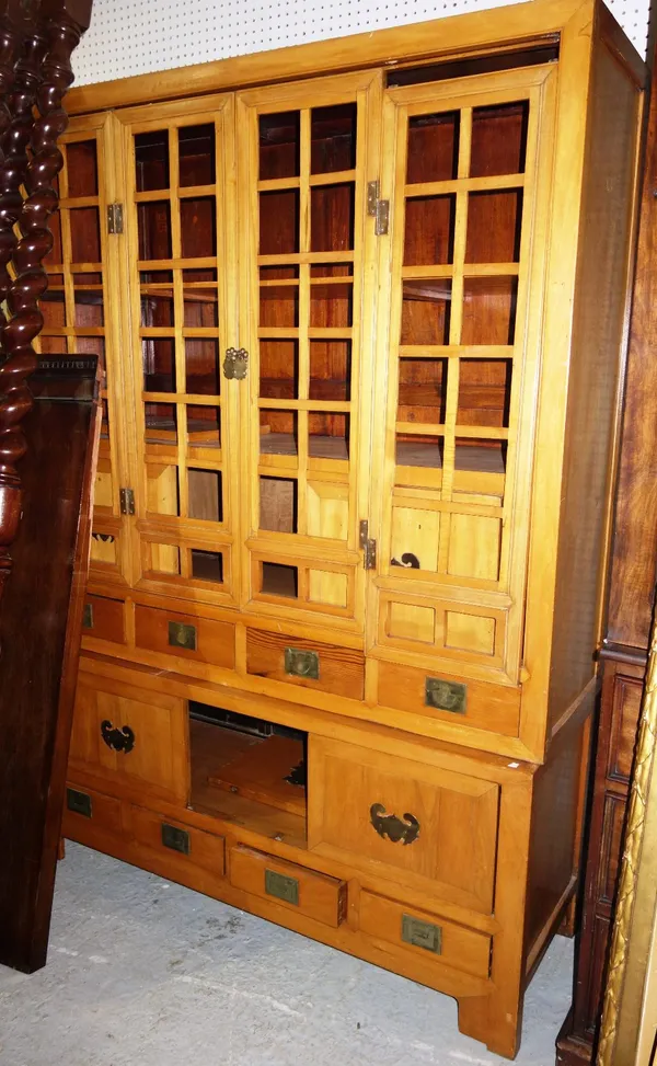 A 20th century Chinese peach wood food cupboard, with four open astragal doors enclosing a shelf and three drawers, above an arrangement of eleven dra