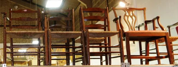 A set of six stained ash Clissett ladder back chairs with rush seats, to include a pair of carvers. (6) (a.f)