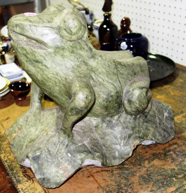 A carved green hardstone model of a frog.