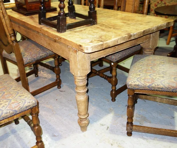 A rectangular pine kitchen table on turned supports and three 20th century beech scullery chairs.