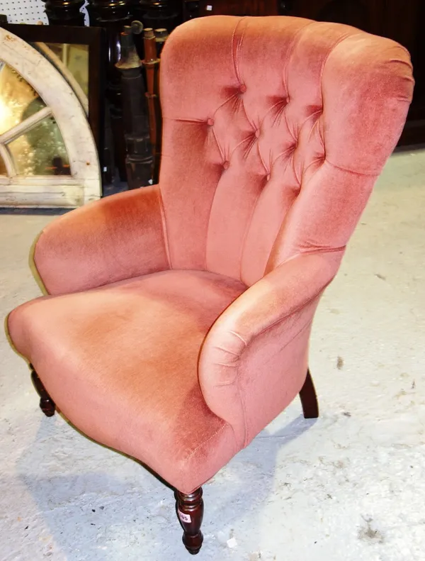 A pink upholstered button back nursing chair.