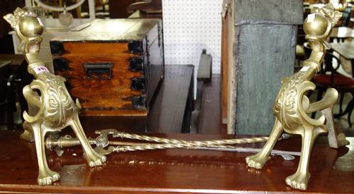 A pair of brass fire dogs and fire tools.