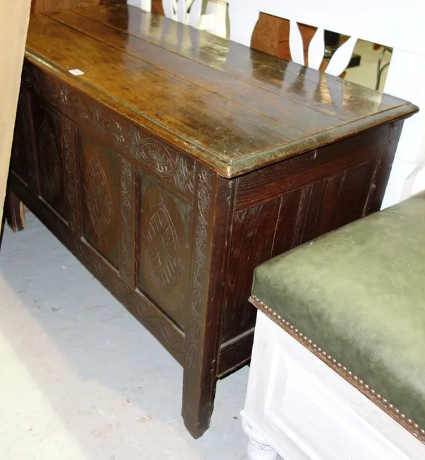 A 17th century oak coffer, the plank top over four carved panel front, on stile feet, 114cm wide.