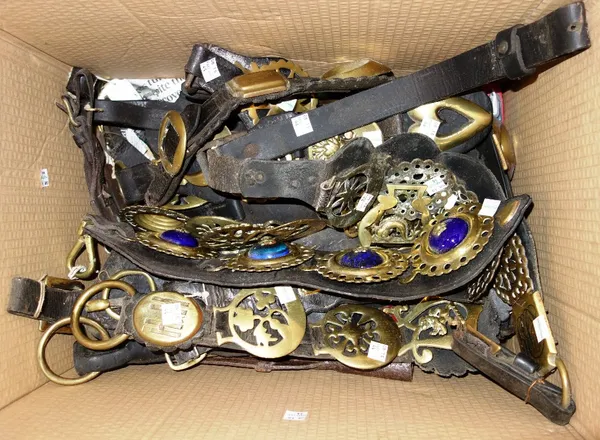 A large quantity of 19th century and later horse brasses- some mounted on leather straps. (qty)