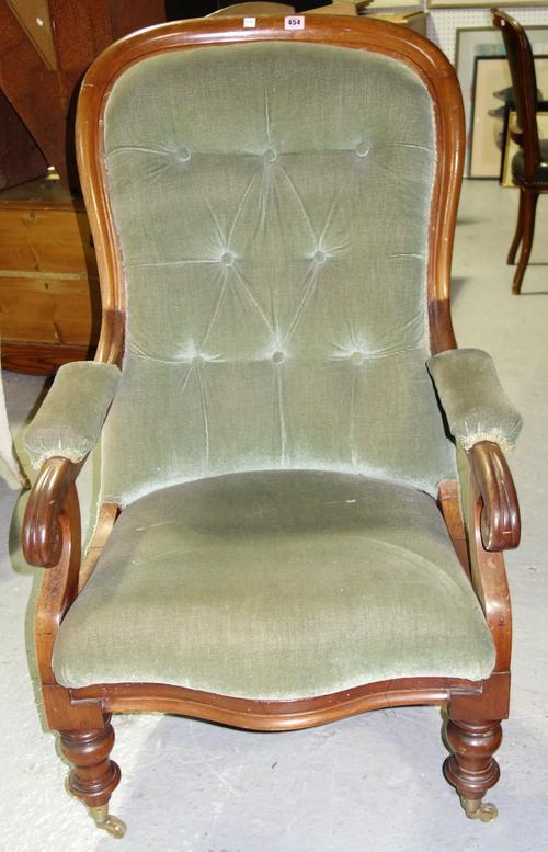 A Victorian mahogany and green upholstered button back commode armchair on turned tapering legs.