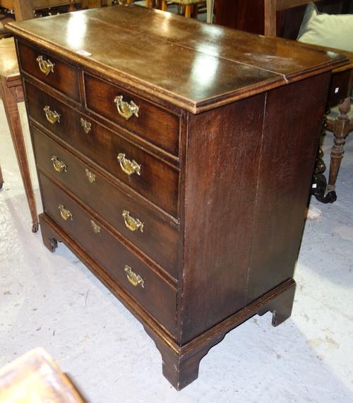 A George III oak chest of two short and three long graduated drawers, on bracket feet, 101cm wide.