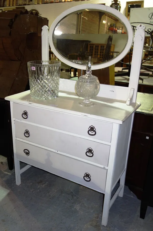 A white painted three drawer dressing table.