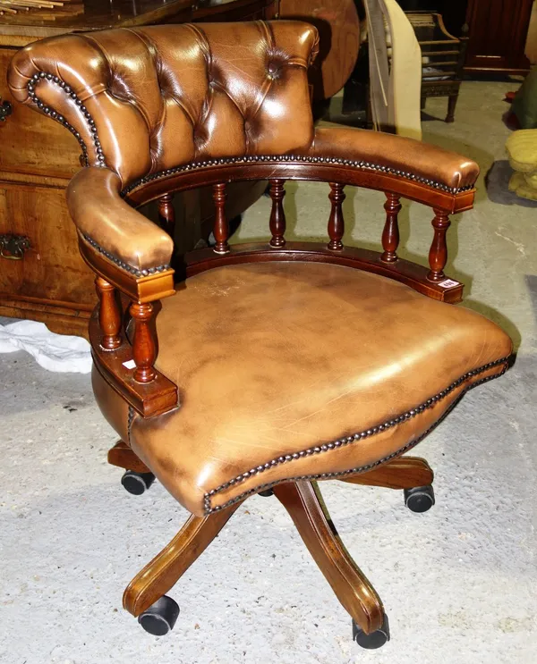A 20th century mahogany and brown leather upholstered office swivel chair.
