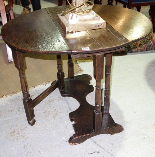 A small oak gateleg table, the oval plank top on baluster turned columns, 82.5cm wide x 81.5cm high x 68cm deep.