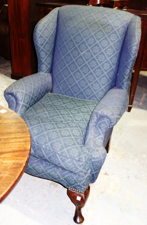 A mahogany framed wingback armchair.