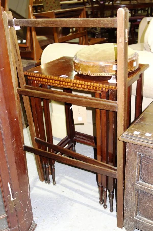 An Edwardian mahogany nest of three tables, together with a mahogany clothes rail and a circular footstool. (3)   10, 70