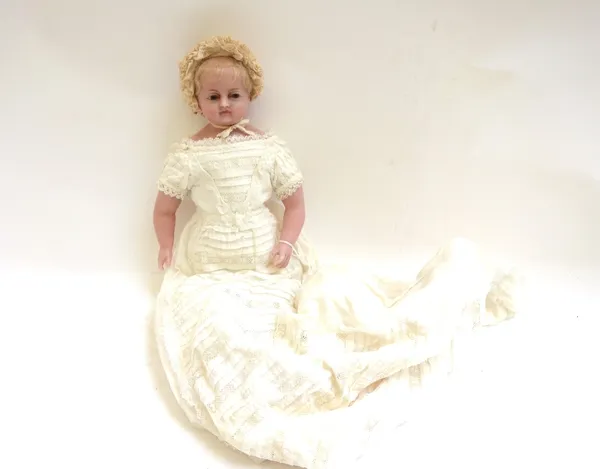 A Continental wax doll, late 19th/early 20th century, with painted face, wax arms and legs, and a stuffed body, in a long white dress (a.f), the doll
