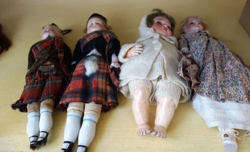 A pair of porcelain dolls, early 20th century, in Highland dress, each with porcelain lower limbs, 35cm high, together with a Heubach Kopplesdorf bisq