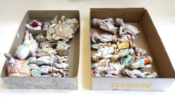 A quantity of early 20th century porcelain pin cushion dollies, mainly Continental, together with a miniature bisque head porcelain doll, a piano doll