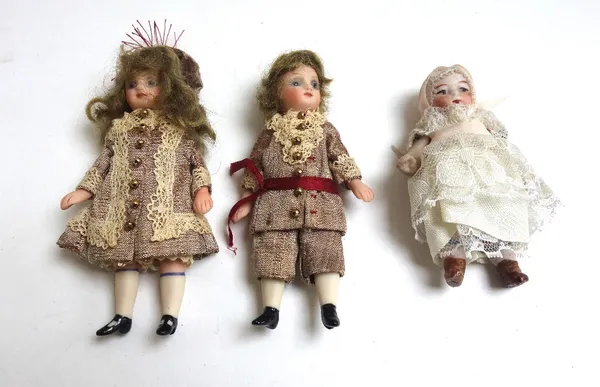 Three Continental miniature bisque head dolls, early 20th century, in period dress, unsigned, 9cm high. (3)