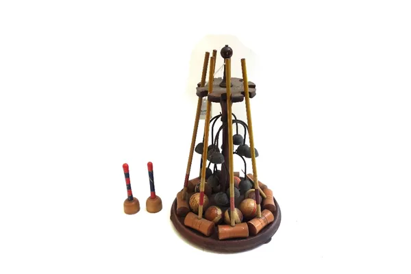 A Victorian table croquet set on a turned mahogany stand, comprising; eight mallets, eight balls, eight hoops and two posts (a.f), 32cm high.