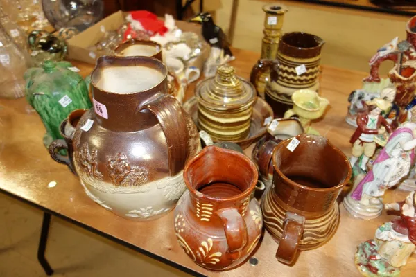 Quantity of British stoneware and slipware to include; three relief decorated Doulton style jugs; assorted jugs, candlestick, mugs etc. (qty)