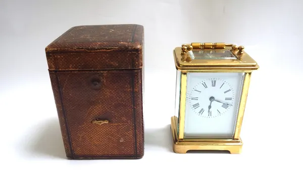 A 20th century French brass cased carriage clock with white enamel dial and Roman numerals, and a single train movement, 11cm high. (key and a leather