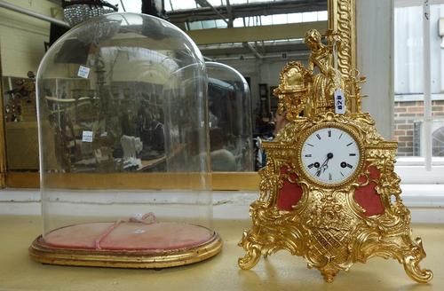 A French gilt metal mantel clock, 19th century, with figural surmount over a foliate and scroll cast case, with a 'Leroy' two train movement, housed u