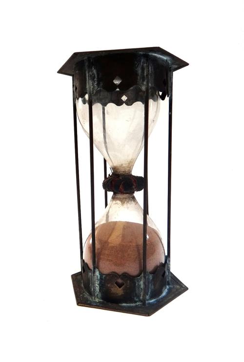 A double sandglass, late 17th century, the bulbs united with string binding, filled with fine grained dark orange sand, the upper and lower hexagonal