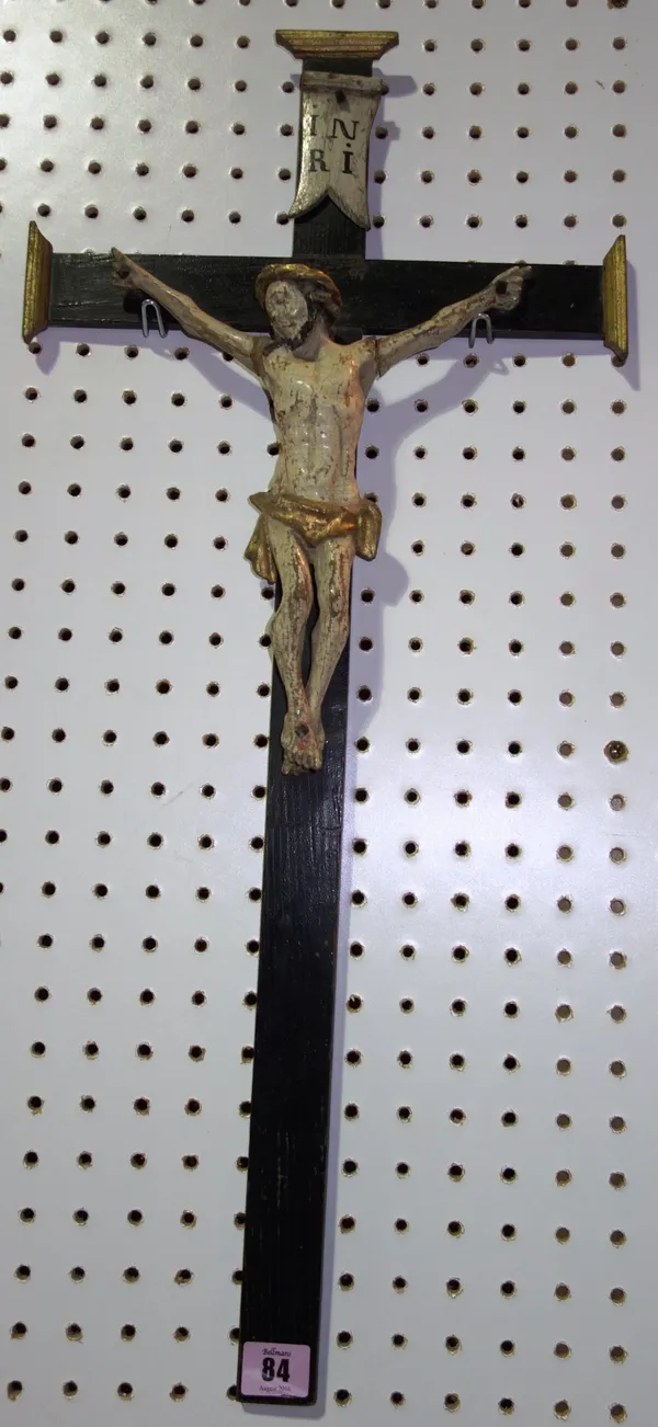 An 18th century and later polychrome figure of Christ, mounted on an ebonised crucifix.