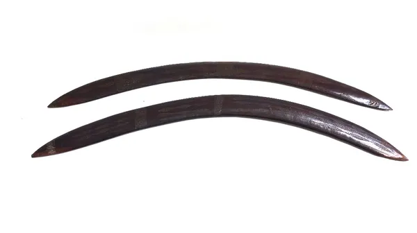 Two Australian Aboriginal boomerangs, early 20th century, carved with geometric patterns, 62cm wide. (2)