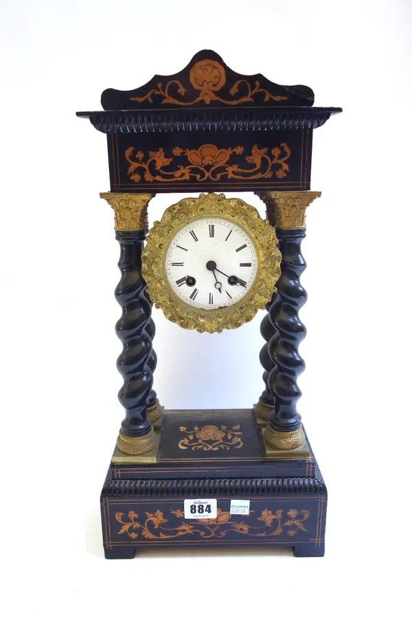 A French ebonised portico mantel clock, 19th century, with inlaid shaped surmount over an enamelled dial, with four barley twist Corinthian columns ov