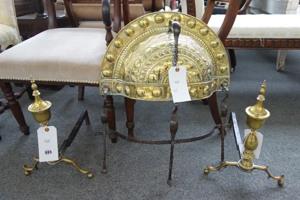 A pair of American brass and wrought iron andirons, circa 1820, 42cm high, and an 18th century pierced brass and wrought iron fire guard. (3)