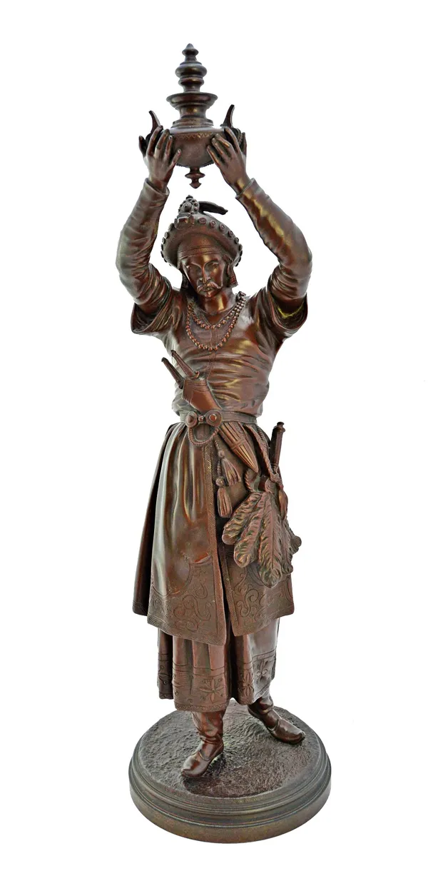 After Emile Picault (1833-1915), a late 19th century bronze figure of a Persian man with arms aloft, holding a two handled urn, on a naturalistic circ