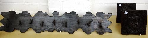 A painted pine game rack, late 18th/early 19th century, with iron hooks, 79cm wide, together with two 18th century oak panels, each carved with a lion