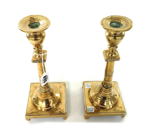 A pair of late 18th century brass candlesticks, with tapering stems and square bases, 27.5cm high, a pair of early 19th century turned brass ejector c