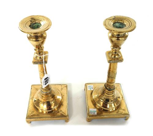A pair of late 18th century brass candlesticks, with tapering stems and square bases, 27.5cm high, a pair of early 19th century turned brass ejector c