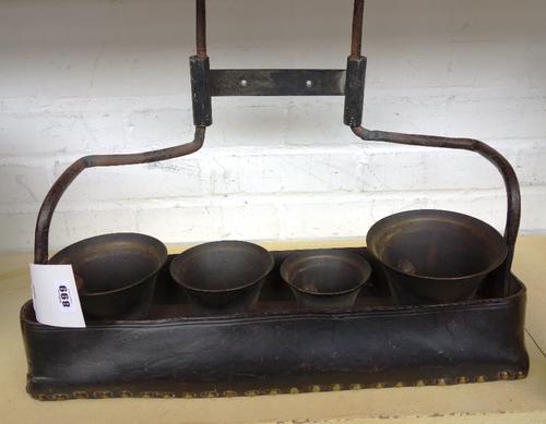 A set of early 19th century coaching bells, stamped 'R.W', with a leather studded footplate, 52cm wide.