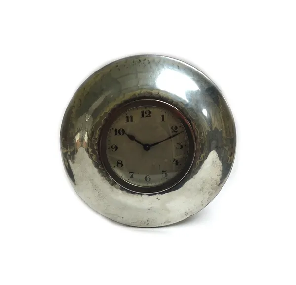 A Liberty & Co Tudric pewter desk clock of circular form, with a beaten finish, 12cm diameter.