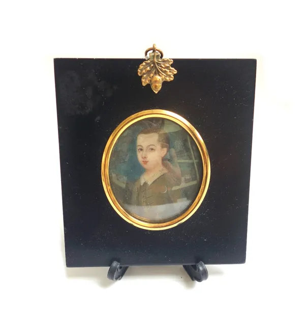An early 18th century portrait miniature on ivory depicting a young boy in period dress, in a gilt metal and ebonised frame, the plaque 5.5cm high.